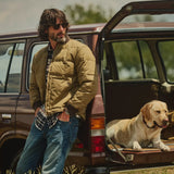 Filson Heritage Cotton Down Jacket In Light Brown, zipped, with brown ribbed collar and cuffs and hands in jean pockets